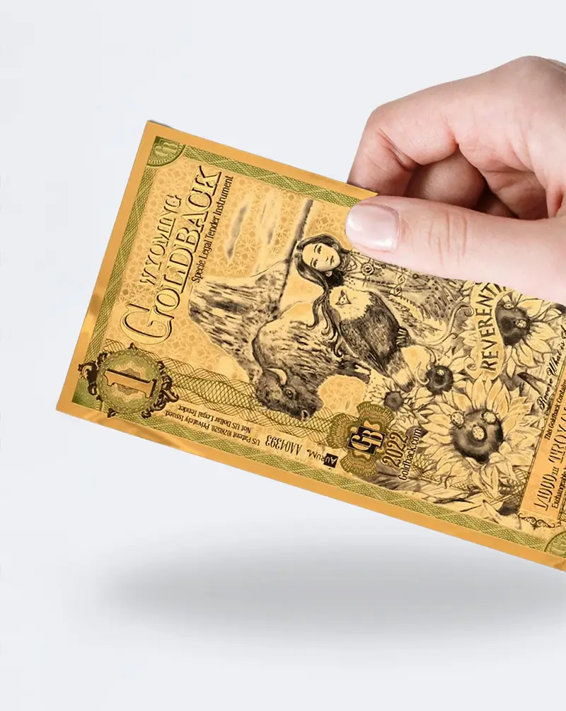 Hand holding Wyoming Goldback currency